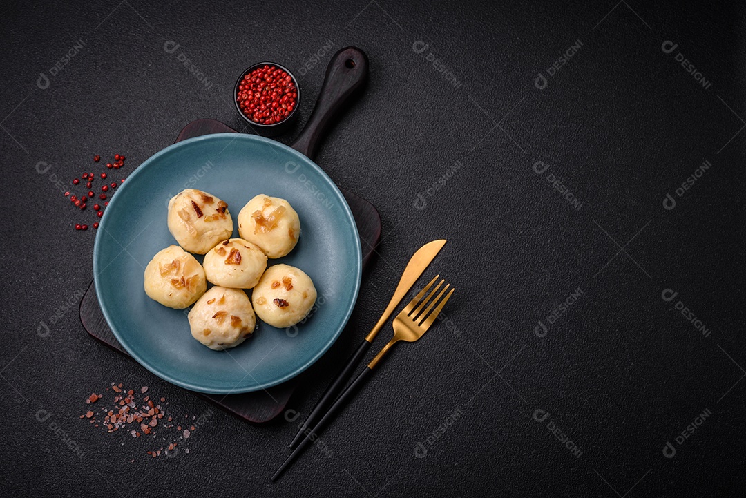 Deliciosos bolinhos caseiros cozidos frescos com queijo, batatas e sal num prato cerâmico