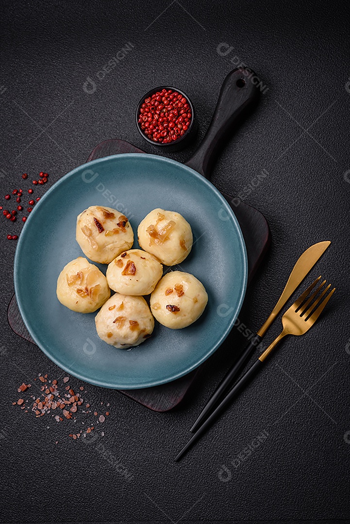 Deliciosos bolinhos caseiros cozidos frescos com queijo, batatas e sal num prato cerâmico