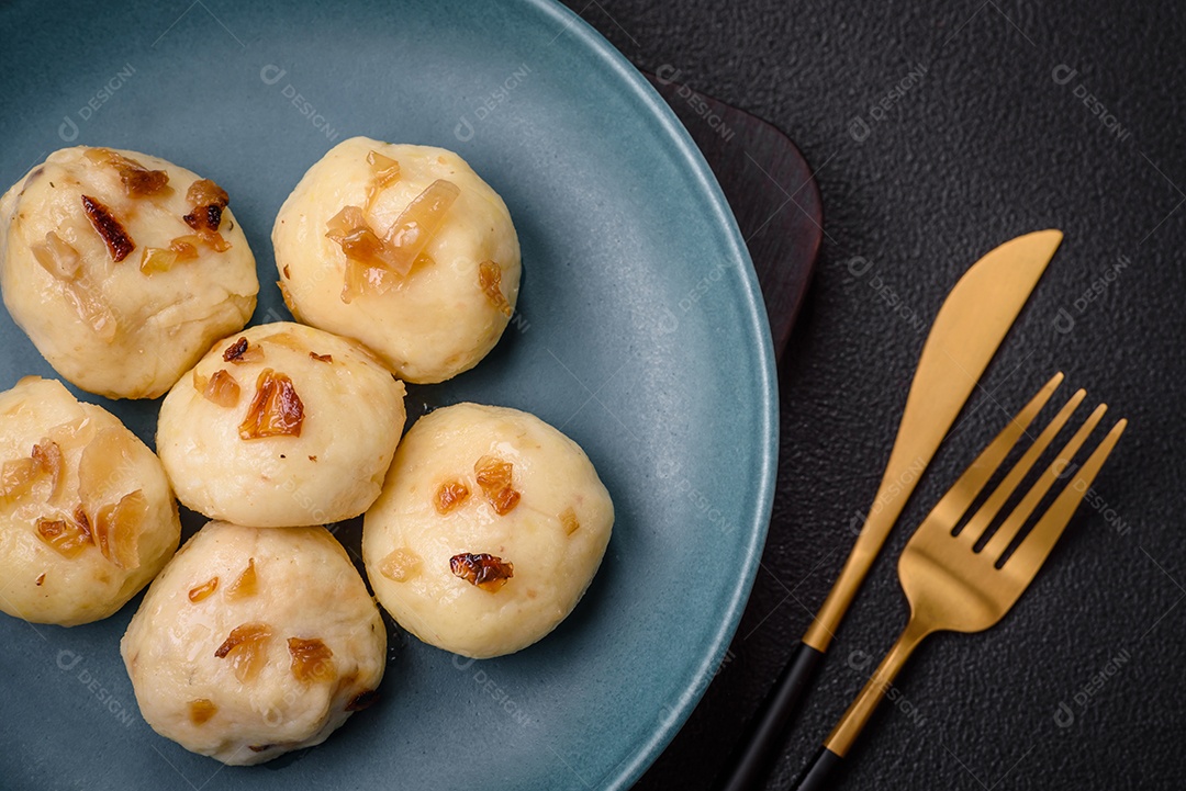 Deliciosos bolinhos caseiros cozidos frescos com queijo, batatas e sal num prato cerâmico