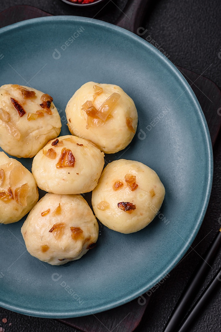 Deliciosos bolinhos caseiros cozidos frescos com queijo, batatas e sal num prato cerâmico