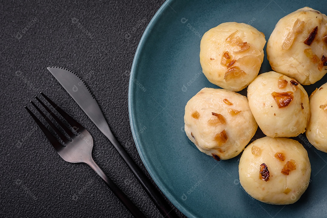 Deliciosos bolinhos caseiros cozidos frescos com queijo, batatas e sal num prato cerâmico