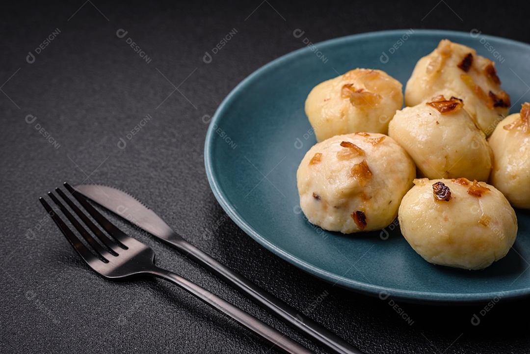 Deliciosos bolinhos caseiros cozidos frescos com queijo, batatas e sal num prato cerâmico