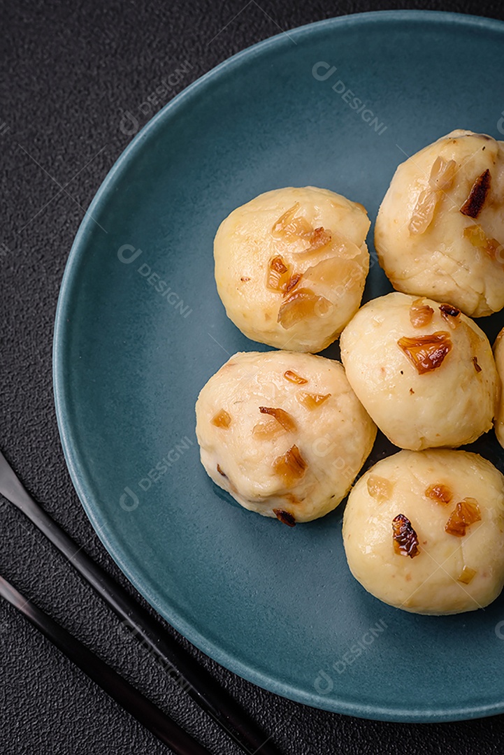 Deliciosos bolinhos caseiros cozidos frescos com queijo, batatas e sal num prato cerâmico