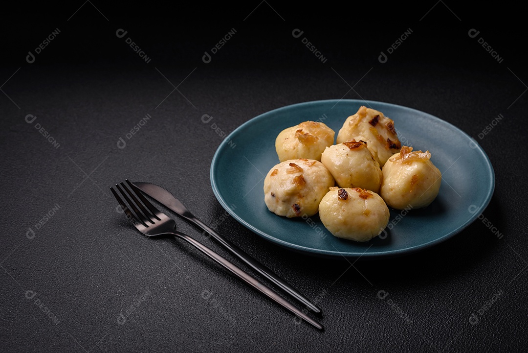 Deliciosos bolinhos caseiros cozidos frescos com queijo, batatas e sal num prato cerâmico