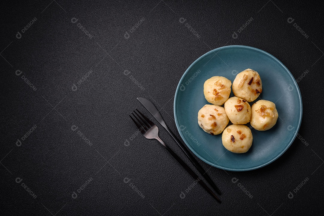 Deliciosos bolinhos caseiros cozidos frescos com queijo, batatas e sal num prato cerâmico