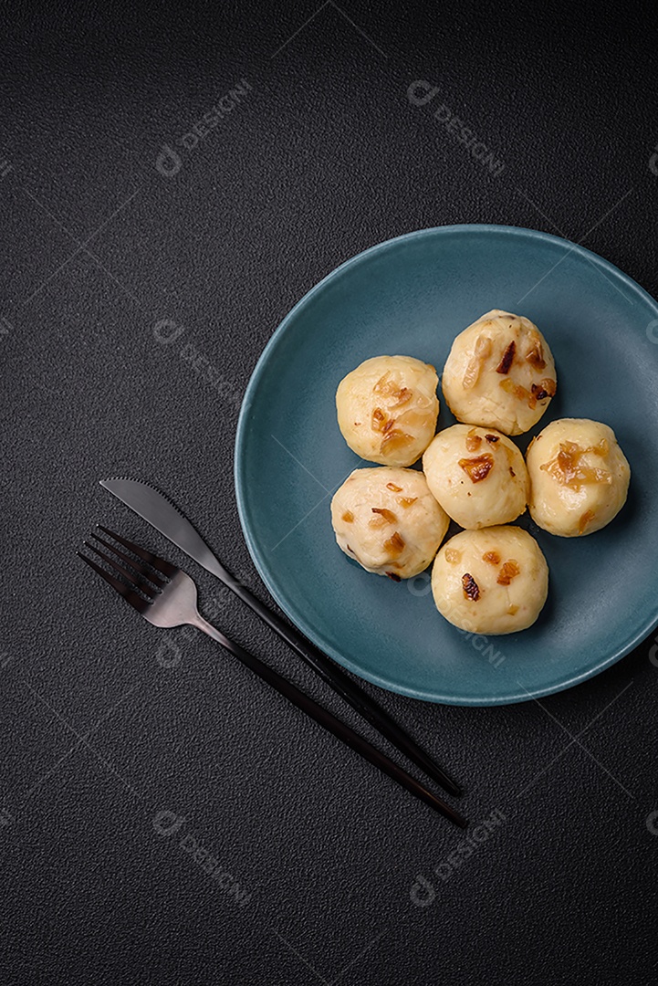 Deliciosos bolinhos caseiros cozidos frescos com queijo, batatas e sal num prato cerâmico