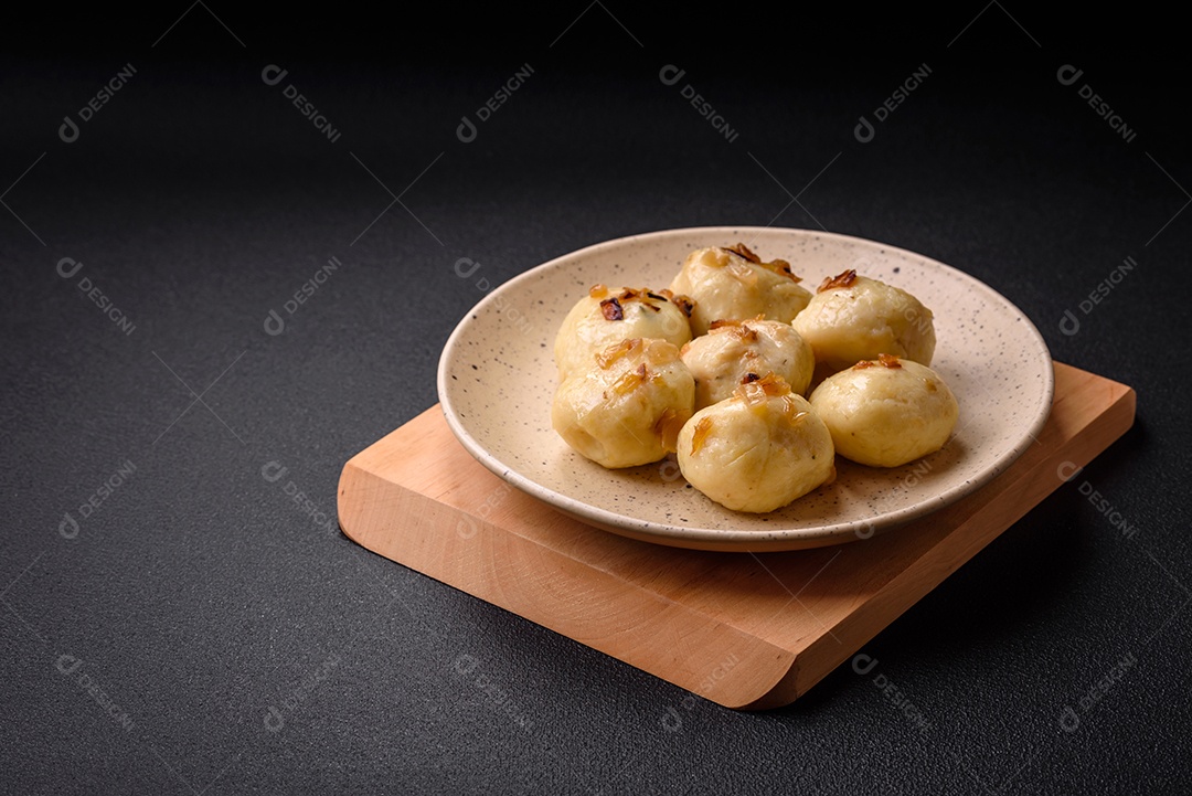 Deliciosos bolinhos caseiros cozidos frescos com queijo, batatas e sal num prato cerâmico