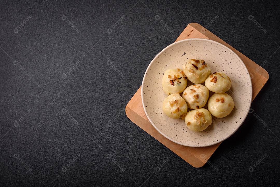 Deliciosos bolinhos caseiros cozidos frescos com queijo, batatas e sal num prato cerâmico