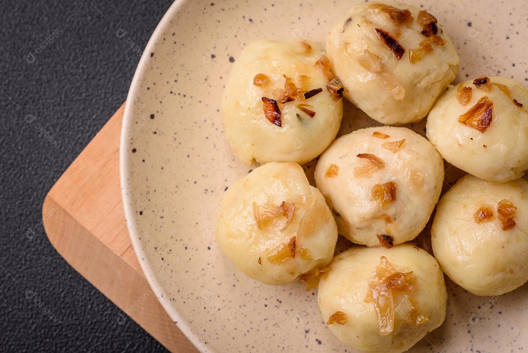 Deliciosos bolinhos caseiros cozidos frescos com queijo, batatas e sal num prato cerâmico