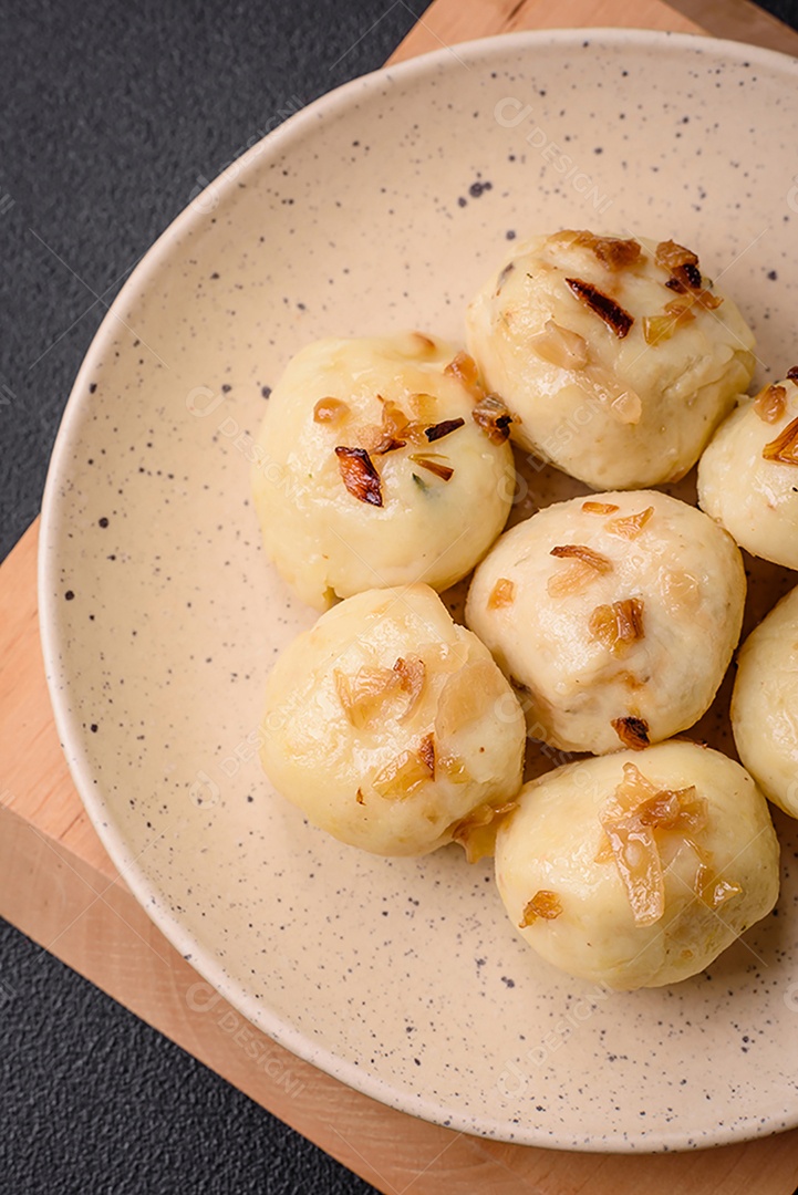 Deliciosos bolinhos caseiros cozidos frescos com queijo, batatas e sal num prato cerâmico