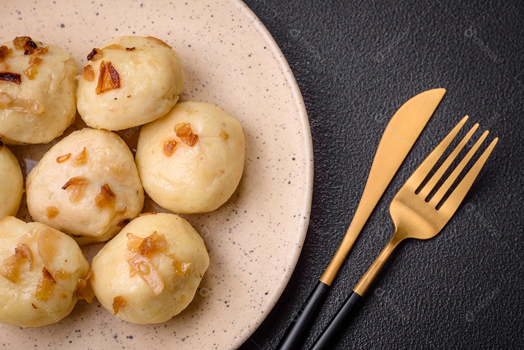 Deliciosos bolinhos caseiros cozidos frescos com queijo, batatas e sal num prato cerâmico