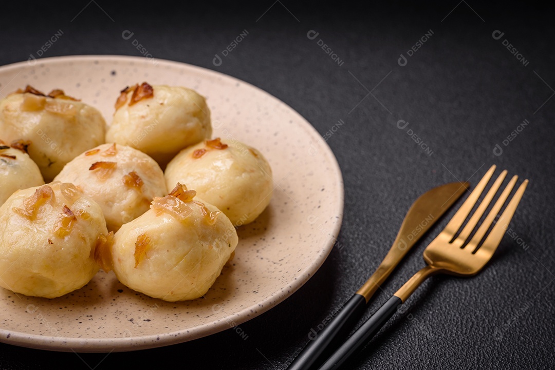 Deliciosos bolinhos caseiros cozidos frescos com queijo, batatas e sal num prato cerâmico