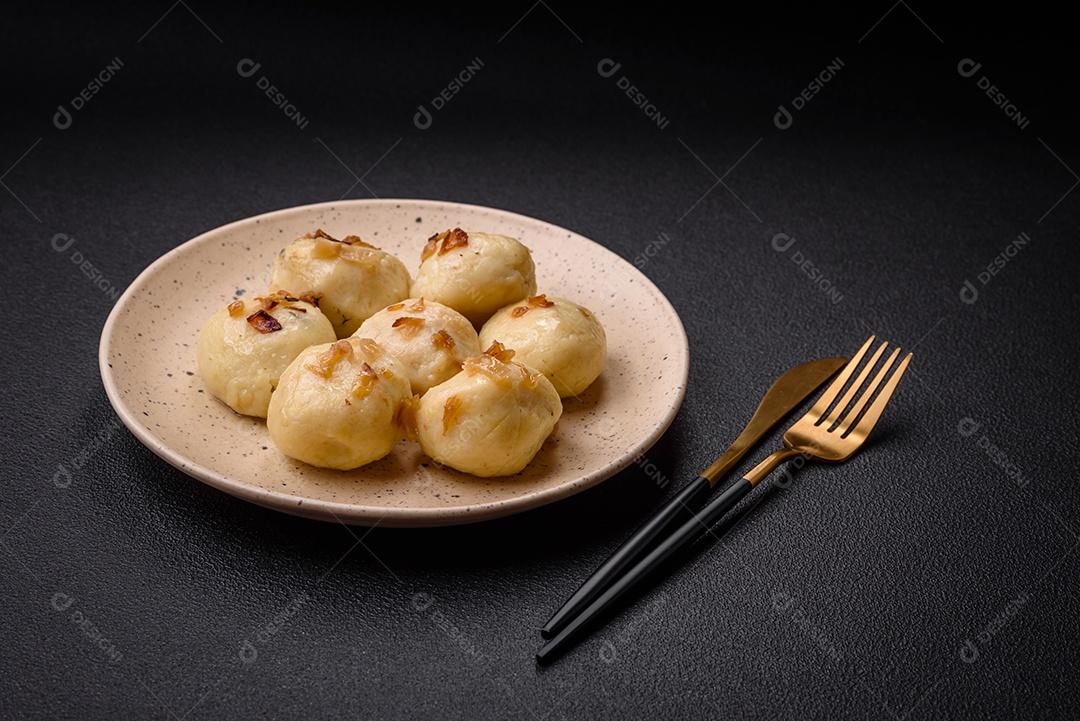 Deliciosos bolinhos caseiros cozidos frescos com queijo, batatas e sal num prato cerâmico