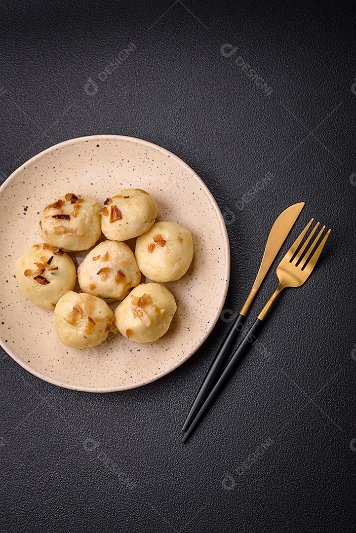 Deliciosos bolinhos caseiros cozidos frescos com queijo, batatas e sal num prato cerâmico
