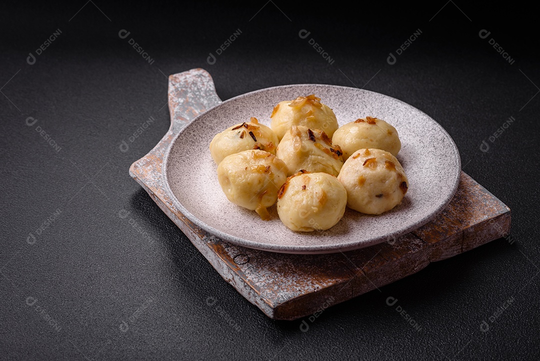 Deliciosos bolinhos caseiros cozidos frescos com queijo, batatas e sal num prato cerâmico