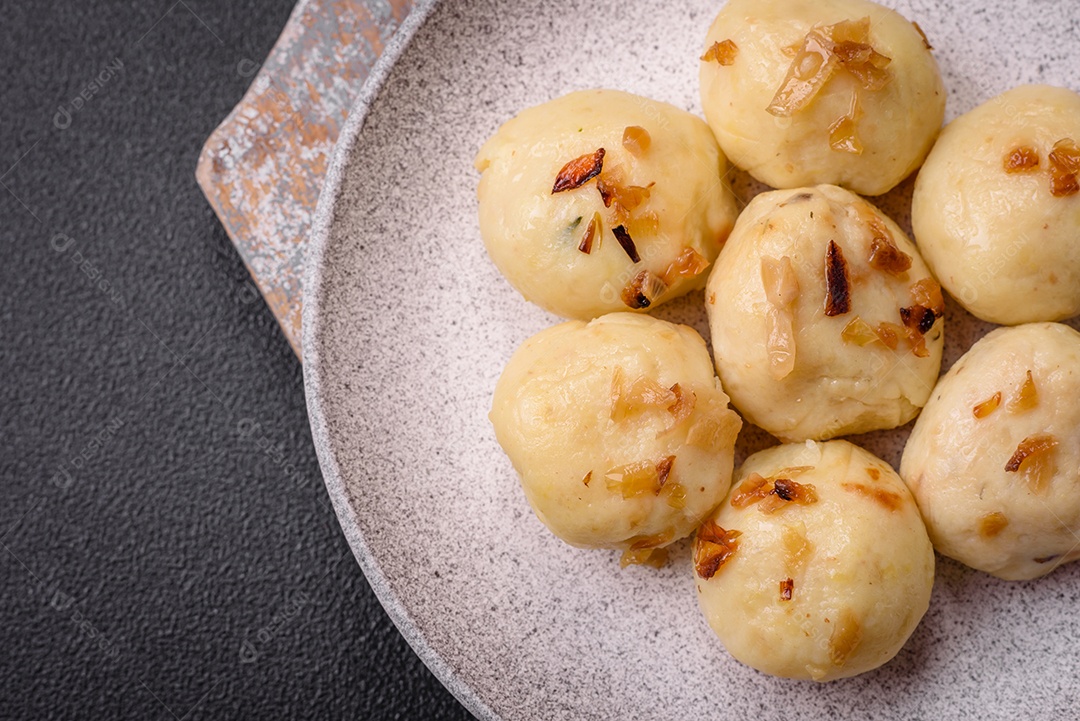 Deliciosos bolinhos caseiros cozidos frescos com queijo, batatas e sal num prato cerâmico
