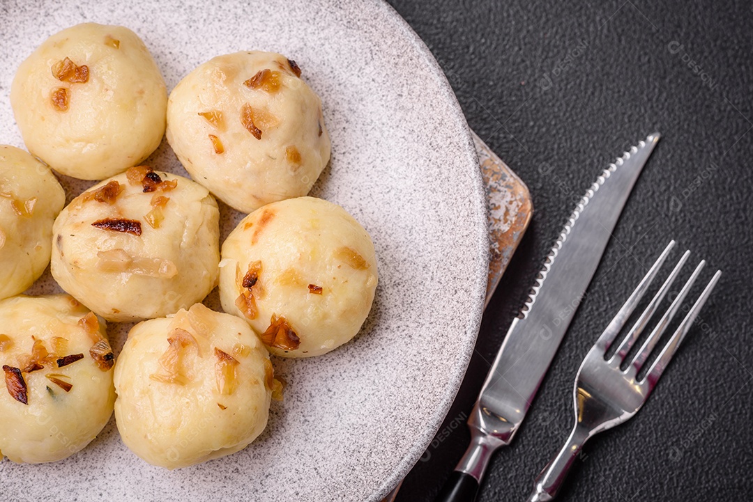 Deliciosos bolinhos caseiros cozidos frescos com queijo, batatas e sal num prato cerâmico