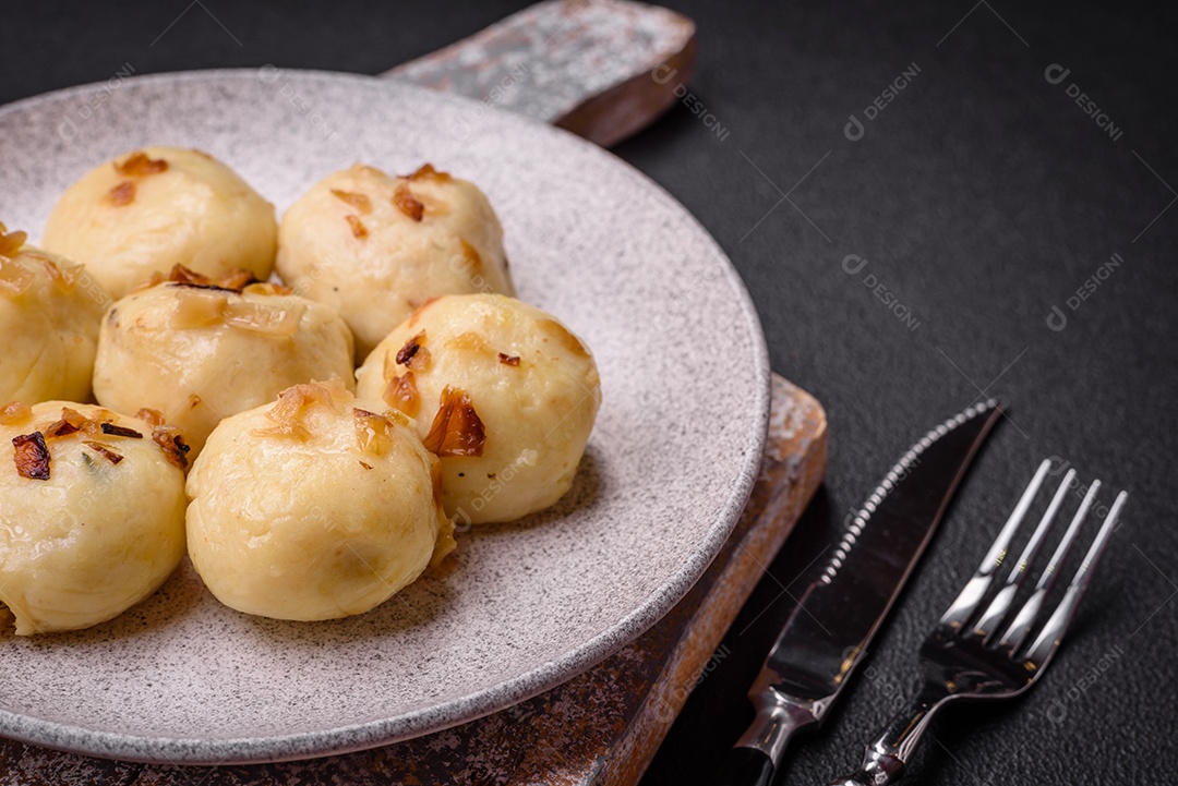 Deliciosos bolinhos caseiros cozidos frescos com queijo, batatas e sal num prato cerâmico