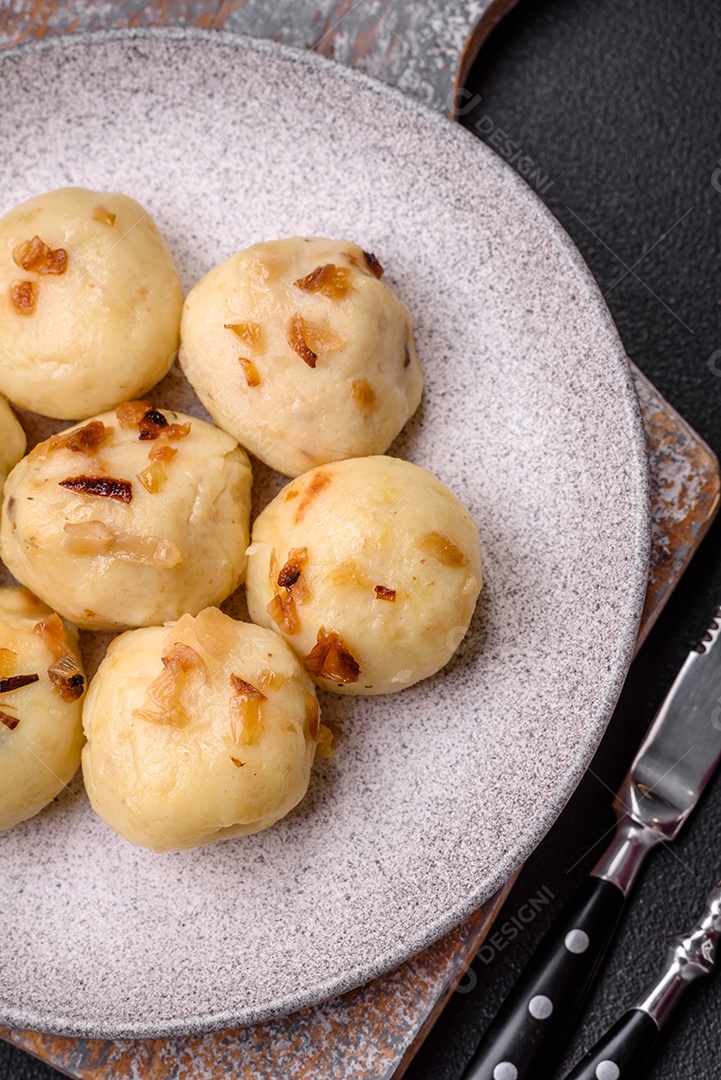 Deliciosos bolinhos caseiros cozidos frescos com queijo, batatas e sal num prato cerâmico