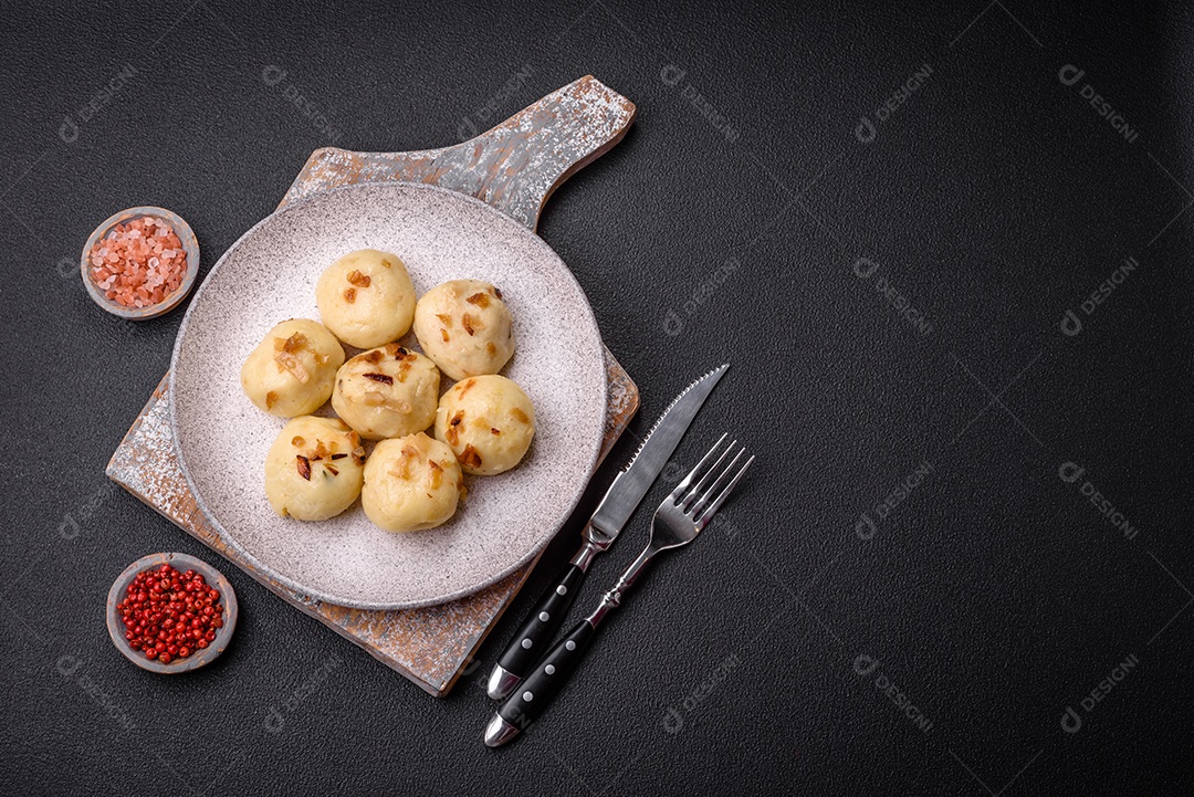 Deliciosos bolinhos caseiros cozidos frescos com queijo, batatas e sal num prato cerâmico