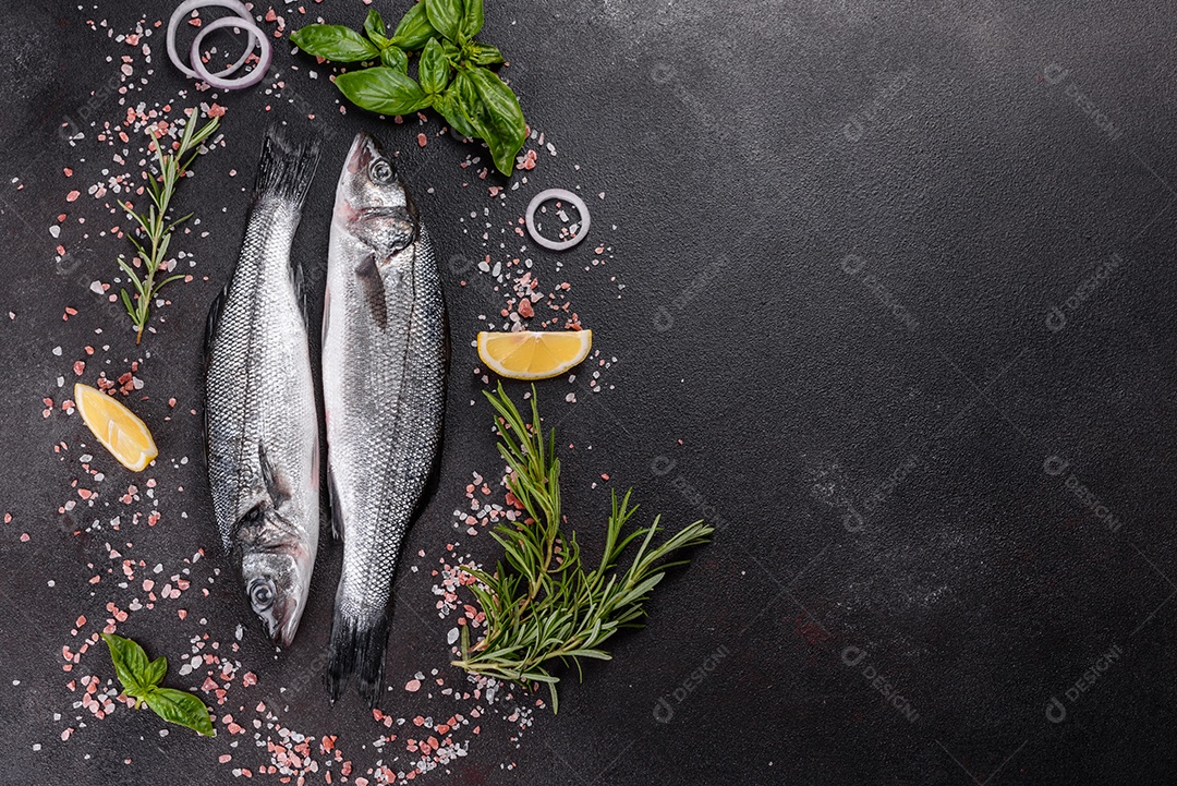 Robalo de peixe fresco e ingredientes para cozinhar. Robalo de peixe cru com especiarias e ervas em uma mesa escura