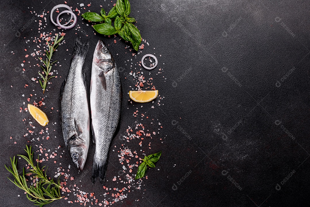 Robalo de peixe fresco e ingredientes para cozinhar. Robalo de peixe cru com especiarias e ervas em uma mesa escura