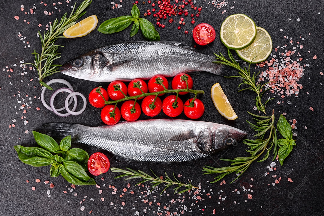 Robalo de peixe fresco e ingredientes para cozinhar. Robalo de peixe cru com especiarias e ervas em uma mesa escura