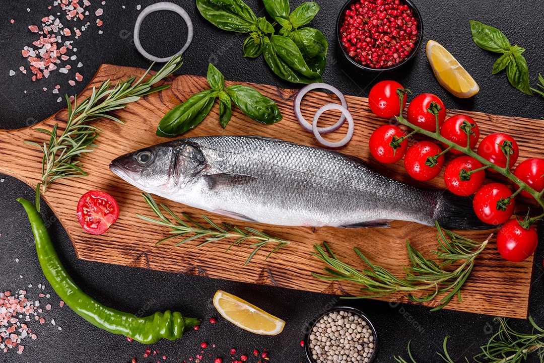 Robalo de peixe fresco e ingredientes para cozinhar. Robalo de peixe cru com especiarias e ervas em uma mesa escura