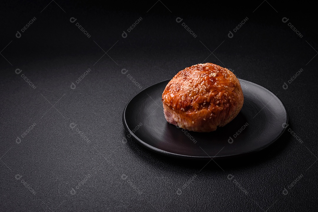 Delicioso rolo de carne de frango ou peru assado com sal e especiarias sobre um fundo de concreto texturizado