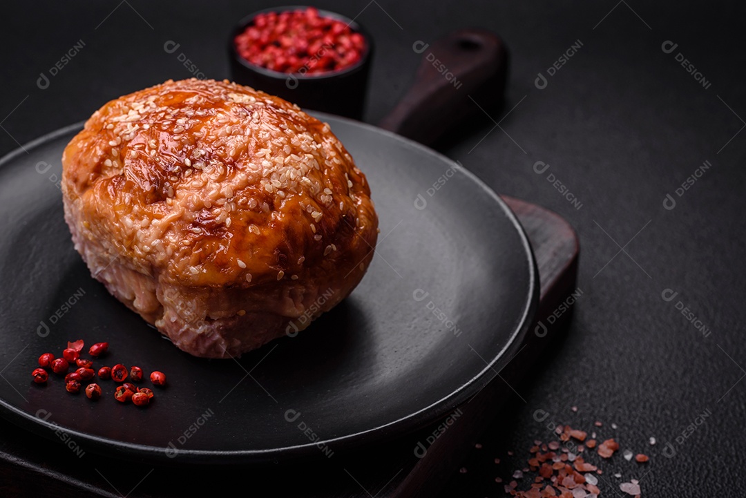 Delicioso rolo de carne de frango ou peru assado com sal e especiarias sobre um fundo de concreto texturizado
