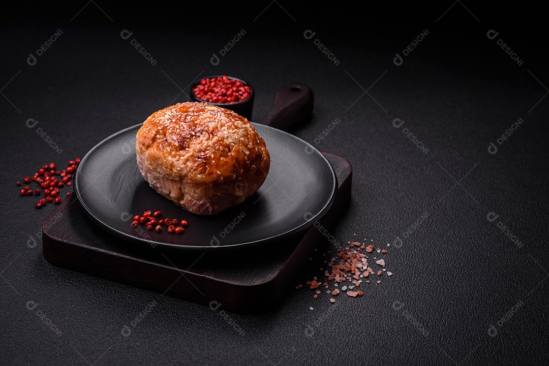 Delicioso rolo de carne de frango ou peru assado com sal e especiarias sobre um fundo de concreto texturizado