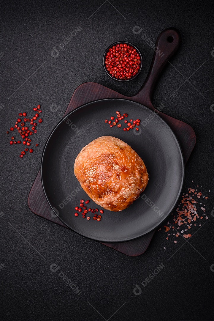 Delicioso rolo de carne de frango ou peru assado com sal e especiarias sobre um fundo de concreto texturizado