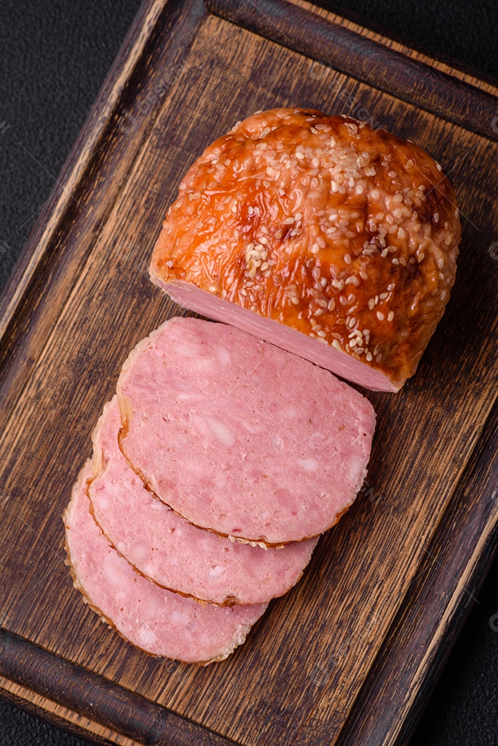 Delicioso rolo de carne de frango ou peru assado com sal e especiarias sobre um fundo de concreto texturizado