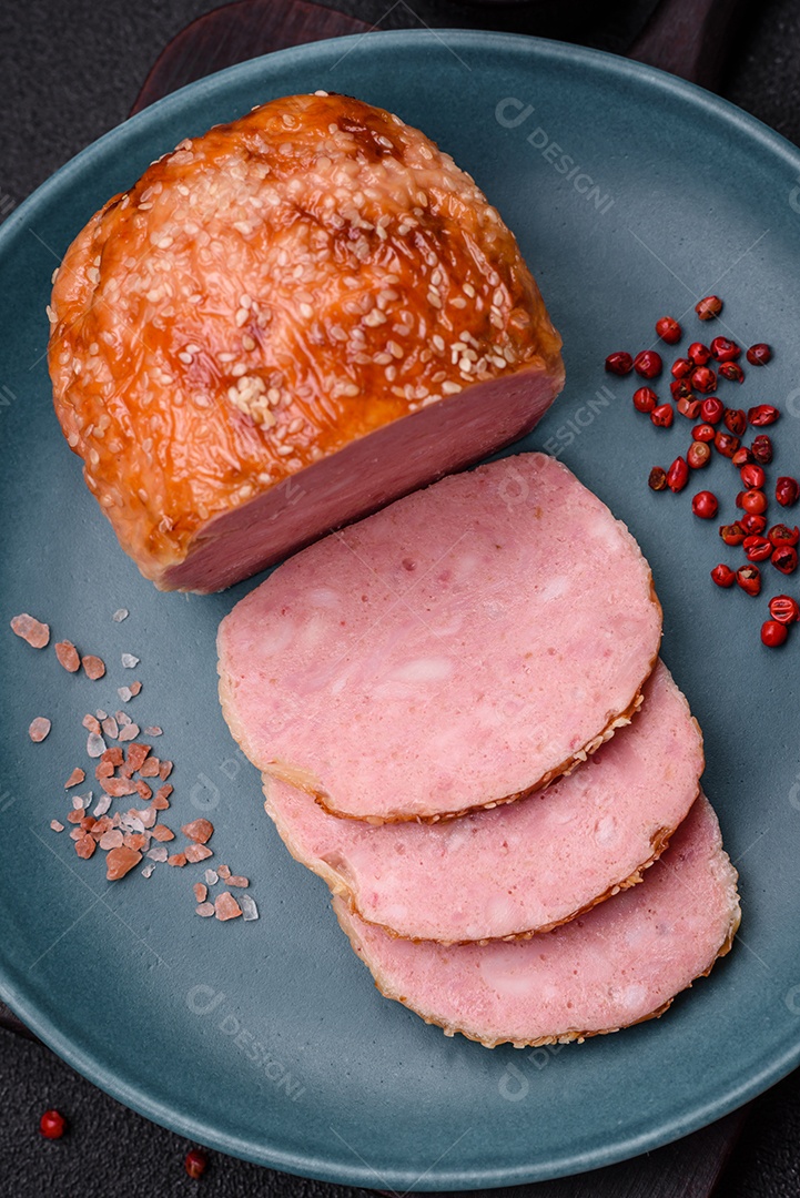 Delicioso rolo de carne de frango ou peru assado com sal e especiarias sobre um fundo de concreto texturizado