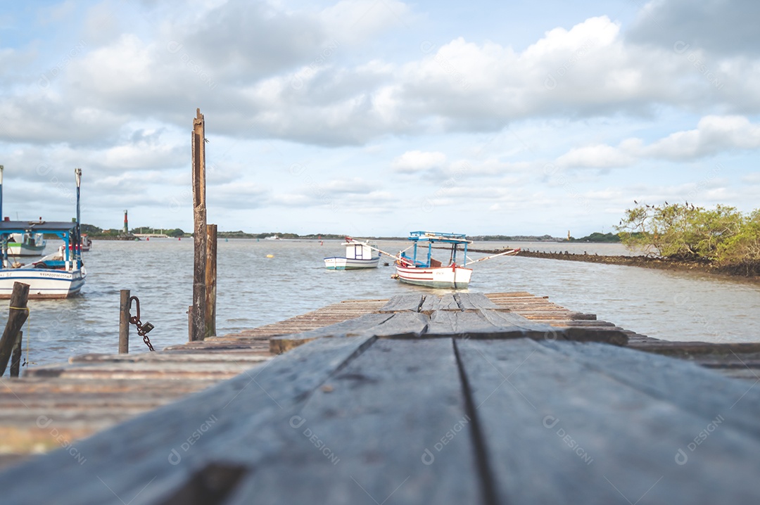 Margem de um lago com maré baixa e lama parando os barcos, conceito de seca no lago