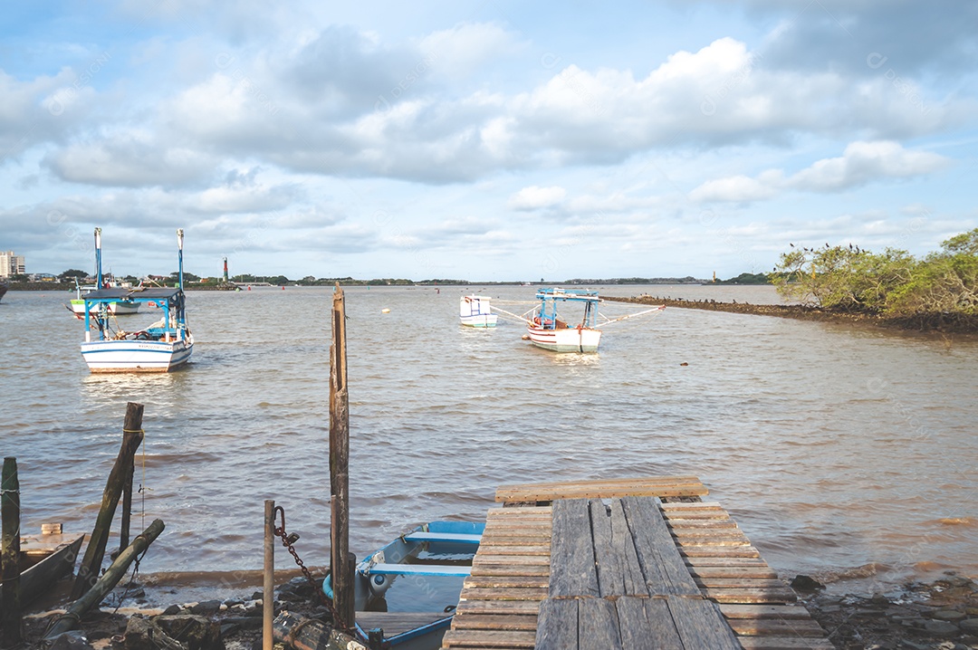 Margem de um lago com maré baixa e lama parando os barcos, conceito de seca no lago