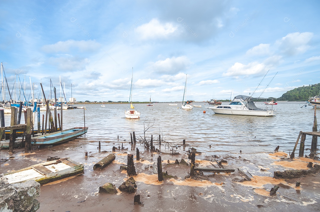 Margem de um lago com maré baixa e lama parando os barcos, conceito de seca no lago.