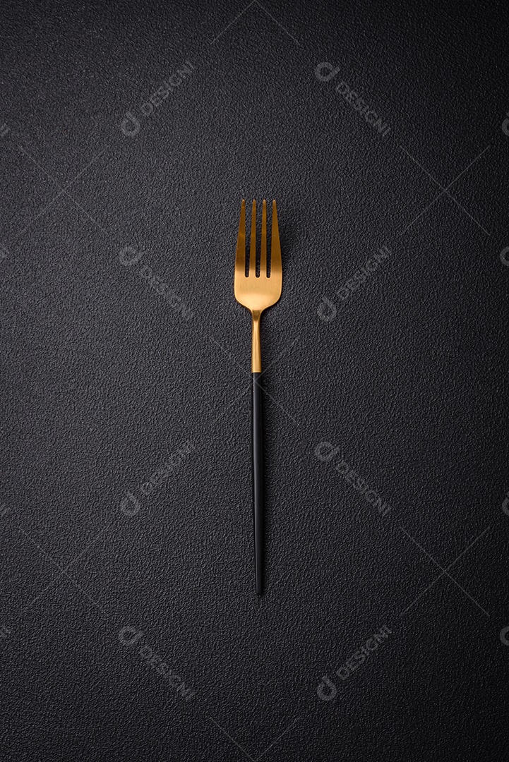Garfo de cozinha feitos de aço em um fundo escuro de concreto