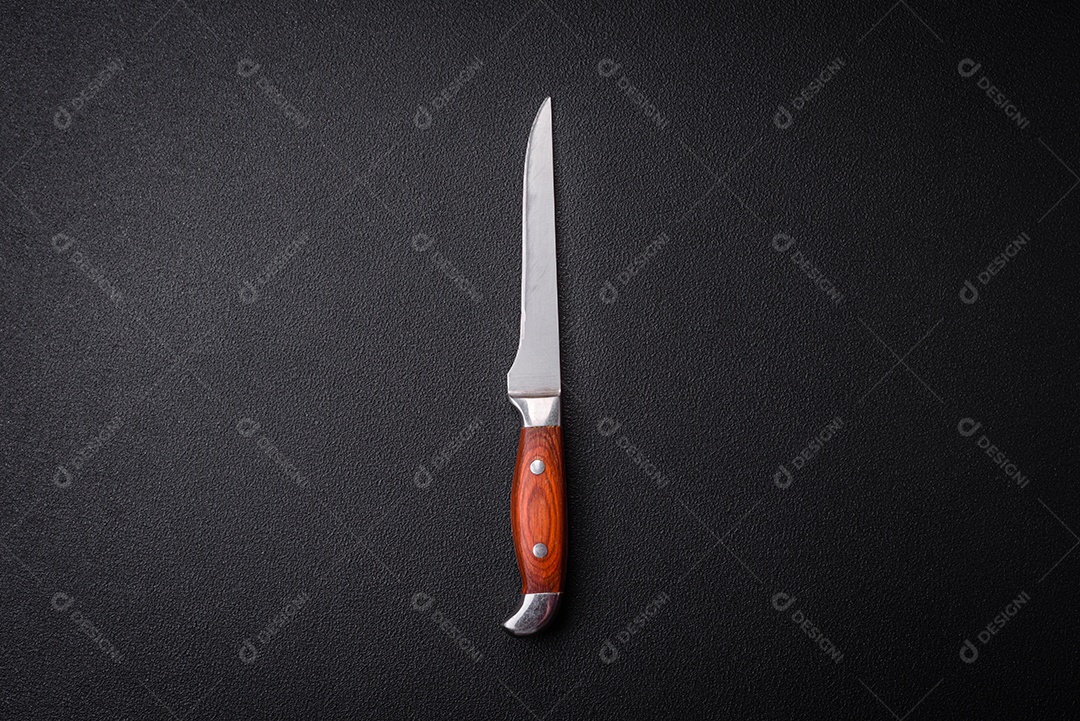 Faca de cozinha feitos de aço em um fundo escuro de concreto