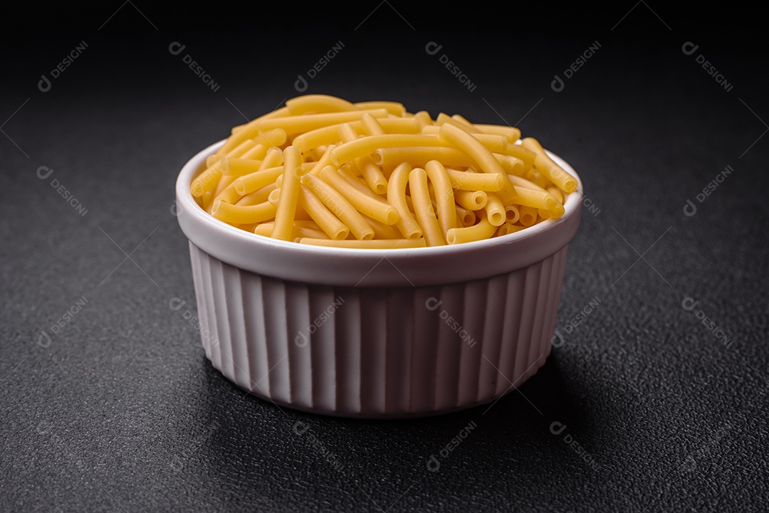 Massa de trigo integral crua com sal e especiarias em uma placa de cerâmica sobre um fundo escuro e texturizado