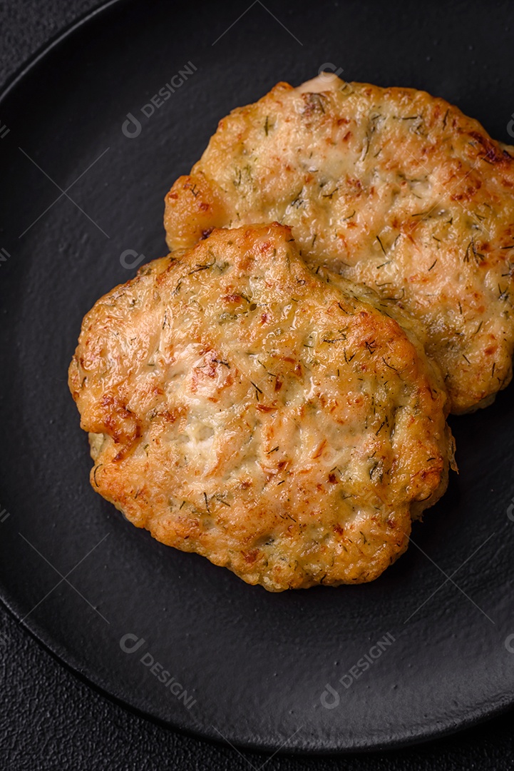 Deliciosas costeletas de peixe picado frito fresco com especiarias e ervas sobre um fundo escuro de concreto