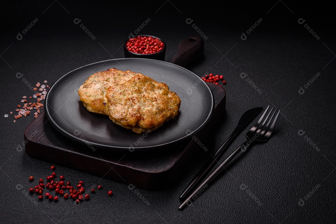 Deliciosas costeletas de peixe picado frito fresco com especiarias e ervas sobre um fundo escuro de concreto