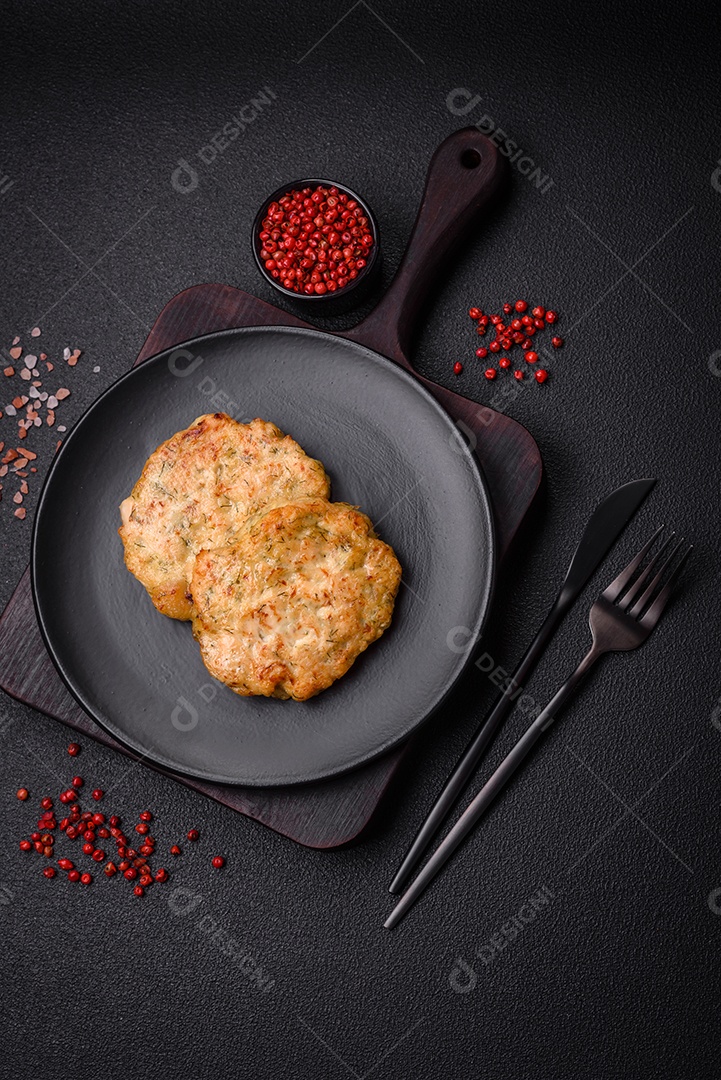 Deliciosas costeletas de peixe picado frito fresco com especiarias e ervas sobre um fundo escuro de concreto