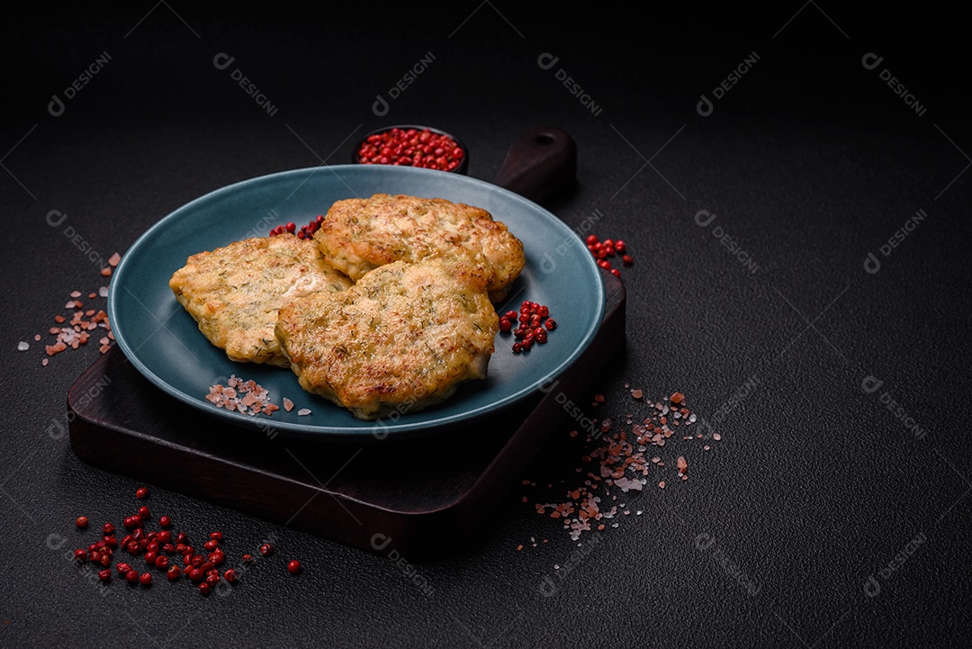 Deliciosas costeletas de peixe picado frito fresco com especiarias e ervas sobre um fundo escuro de concreto