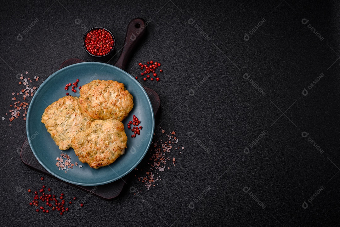 Deliciosas costeletas de peixe picado frito fresco com especiarias e ervas sobre um fundo escuro de concreto