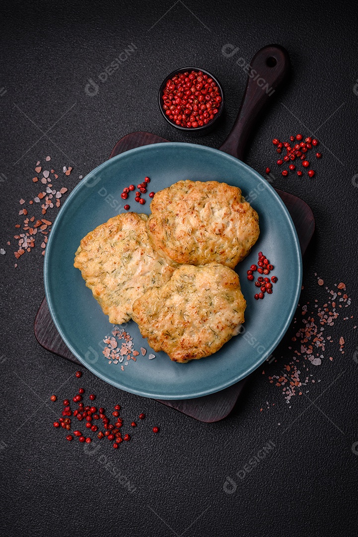 Deliciosas costeletas de peixe picado frito fresco com especiarias e ervas sobre um fundo escuro de concreto