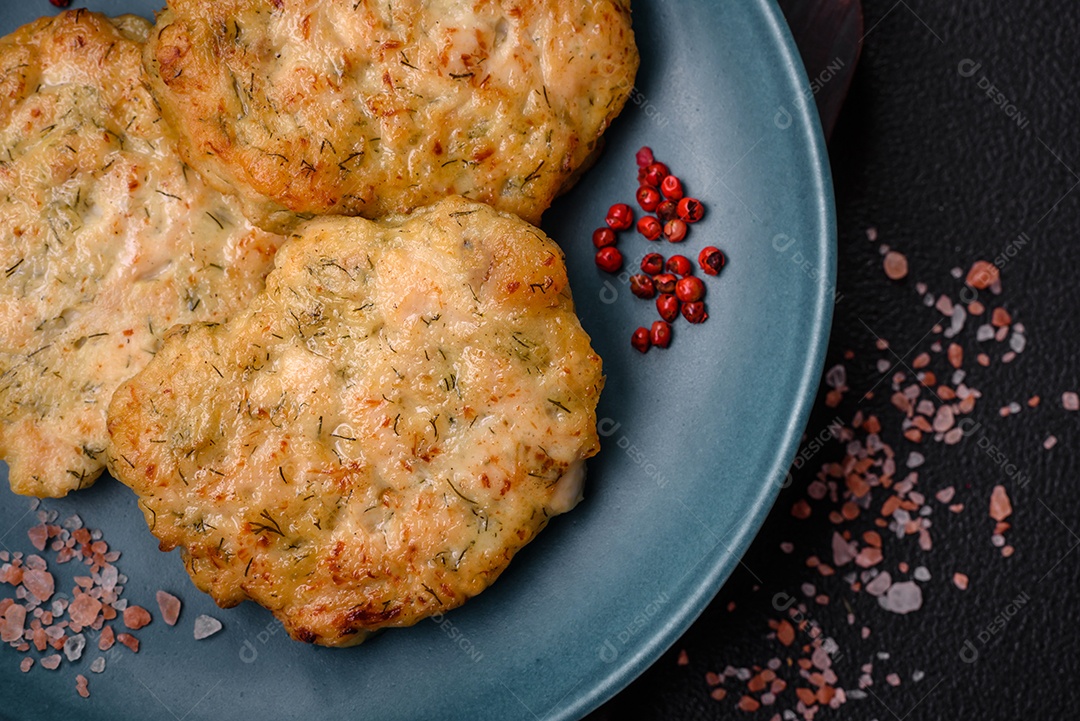 Deliciosas costeletas de peixe picado frito fresco com especiarias e ervas sobre um fundo escuro de concreto