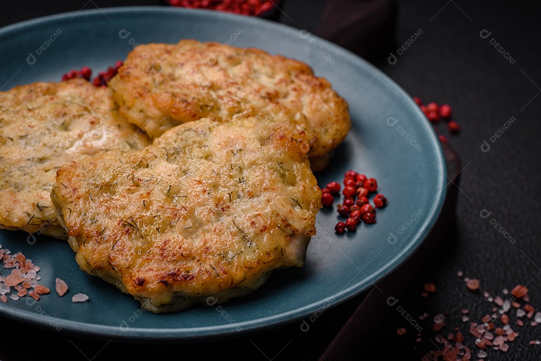 Deliciosas costeletas de peixe picado frito fresco com especiarias e ervas sobre um fundo escuro de concreto