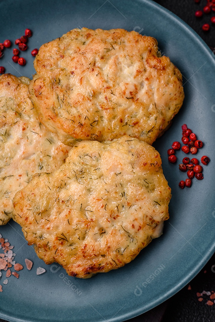 Deliciosas costeletas de peixe picado frito fresco com especiarias e ervas sobre um fundo escuro de concreto