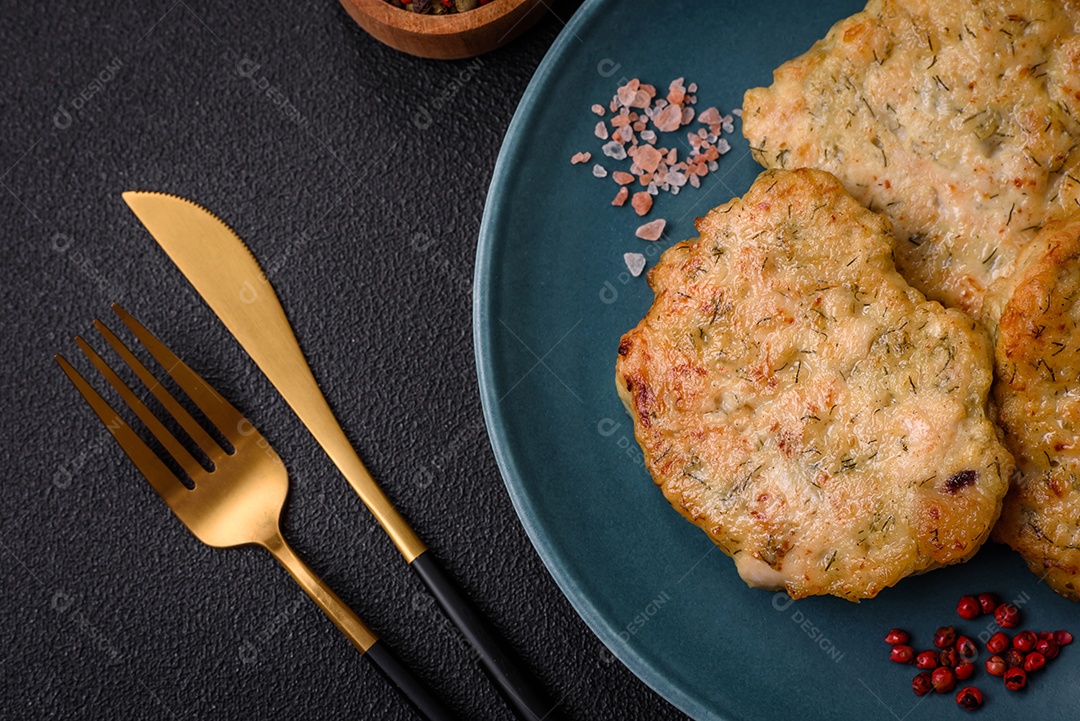 Deliciosas costeletas de peixe picado frito fresco com especiarias e ervas sobre um fundo escuro de concreto